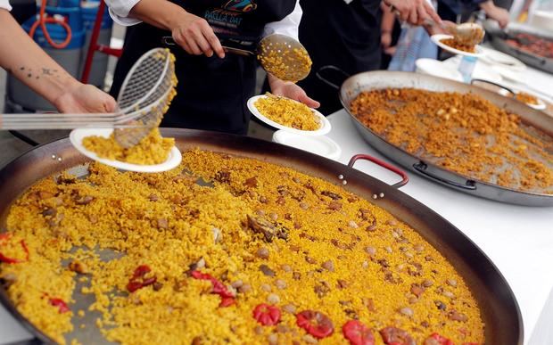 Varias personas reparten paella en la plaza del Ayuntamiento de Valencia, en una fotografía de archivo. 