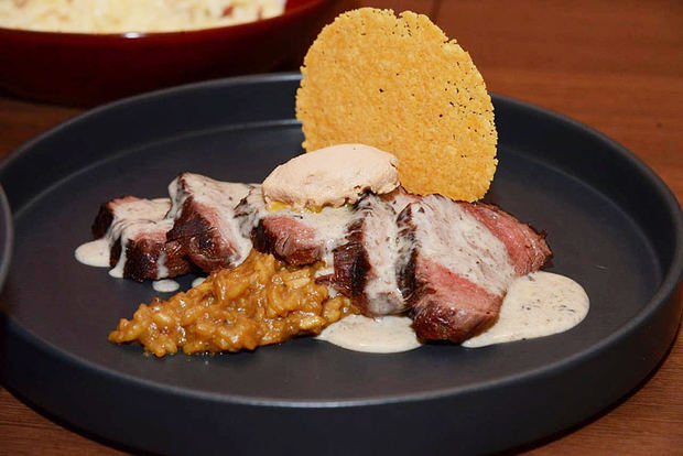 Filete de res con salsa de trufas y foie gras servido con risotto de hongos porcini.