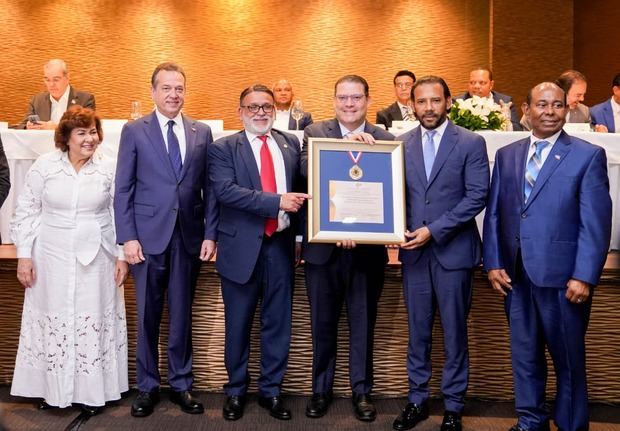 Iván de Jesús García, presidente de la Federación Dominicana de Comerciantes, hace entrega de la placa de reconocimiento como “Servidor Público 2025” a Yayo Sanz Lovatón, le acompañan Víctor -Ito- Bisono y demás miembros de la entidad.