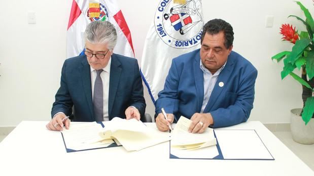 Jhon Richard Paniagua y Roberto Santana firman el acuerdo.