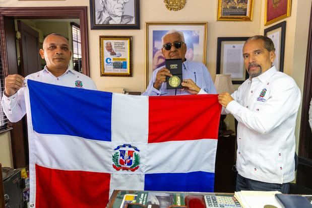 Juan Pablo Uribe le entrega la medalla conmemorativa y Bandera Nacional a Euclides Gutiérrez Félix.