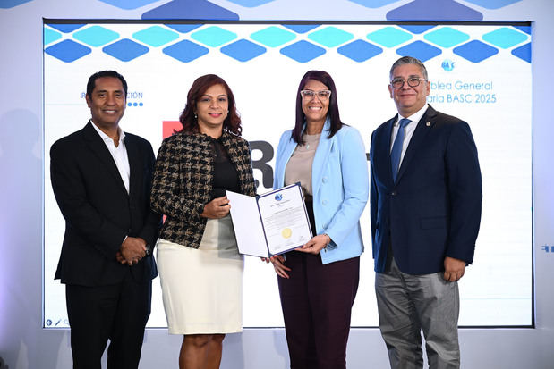 El agregado regional del Caribe de las Aduanas y Protección Fronteriza (CBP), de los Estados Unidos, Abdías Ortiz y el presidente de BASC Dominicana, Horacio Lomba, entregan una certificación en seguridad bajo la norma BASC a Laboratorios Rowe, el cual fue recibido por representantes, Wendy Villa y Juarsenny Castro.