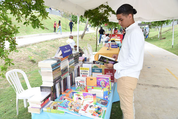 César Fernández  lee libros en exhibición.