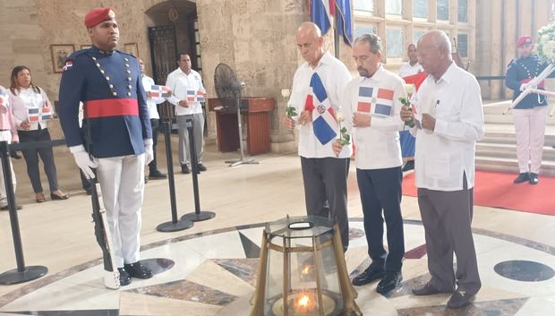 Luis De León, Juan Pablo Uribe y Andrés Dirocié Montás, al colocar la flor en la llama votiva.