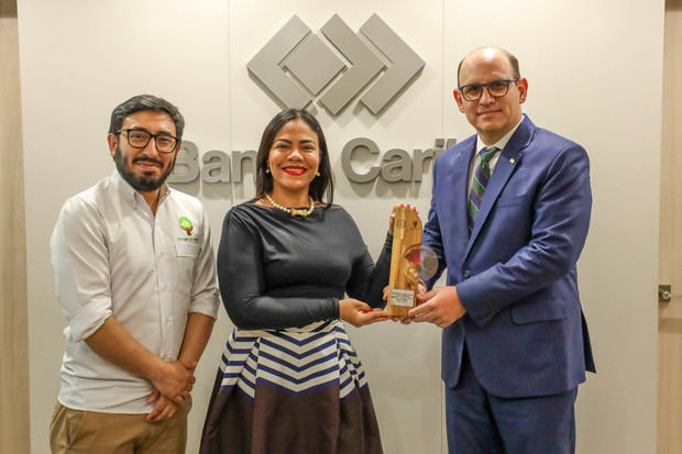 A la izquierda, el presidente ejecutivo de Banco Caribe, Edgar del Toro, recibe la distinción de manos de la consultora líder de la empresa GreEnergy Dominicana, Yomayra Martinó y del director de operaciones de la firma “CO2 Cero”, de Colombia, Daniel Vargas.