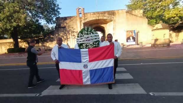 Cruzando la ofrenda de floral del altar de la patria a la estatua de Francisco Alberto Caamaño. 