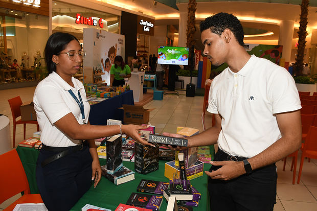 Melany Feliz asesorando a Brayan Manuel Castillo, en la compra de un libro.