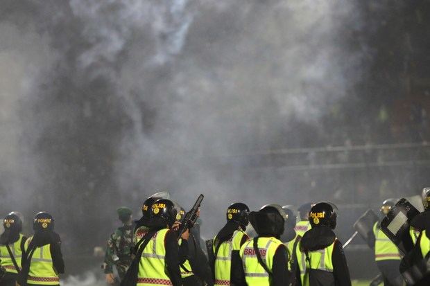 Policía trata de hacer frente a los aficionados que abarrotan el campo de Kanjuruhan, en la isla de Java, Indonesia.