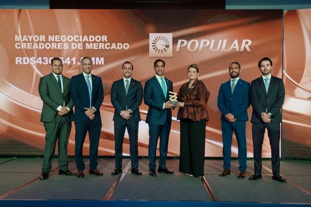 El señor Edward Baldera, vicepresidente de Tesorería, Mercado de Capitales y Banca Institucional del Banco Popular, junto a su equipo, recibió el premio de manos de Elianne Vilchez, vicepresidenta ejecutiva de la Bolsa y Mercado de Valores de la República Dominicana.