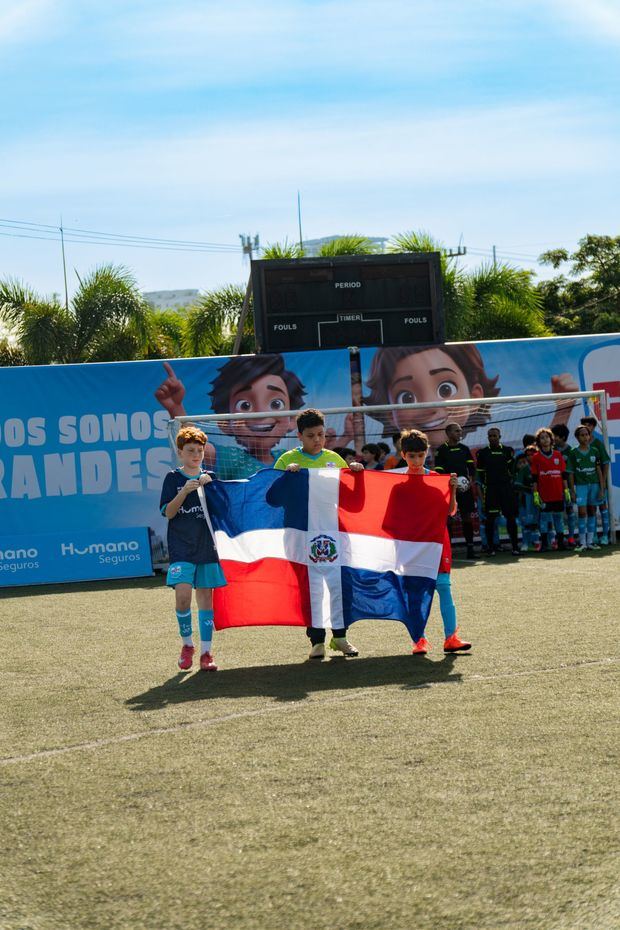 Niños portando bandera en apertura.