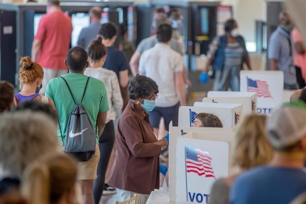 Personas buscan su lugar de votación durante unas elecciones estadounidenses, en una fotografía de archivo.