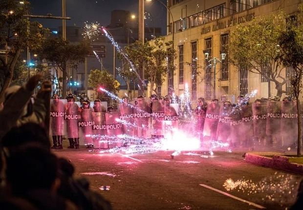 Policías peruanos frente a manifestantes en Lima en los exteriores del Congreso.