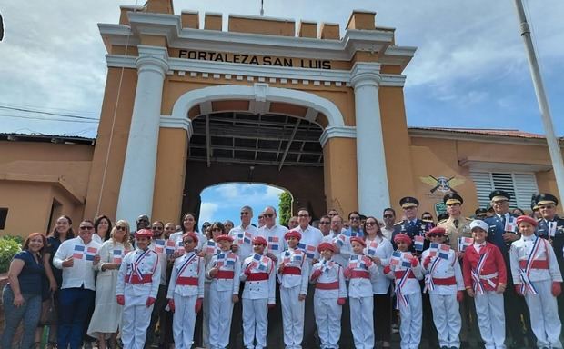 Autoridades civiles y militares junto a los estudiantes posan frente a la Fortaleza San Luis en Santiago.