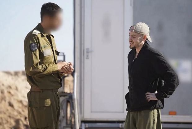 El rehén Eitan Mor (d) conversa con un representante de las Fuerzas de Defensa de Israel (FDI) tras su liberación este 13 de octubre.