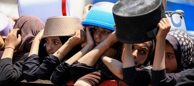Un grupo de palestinas espera la entrega de alimentos en Ciudad de Gaza