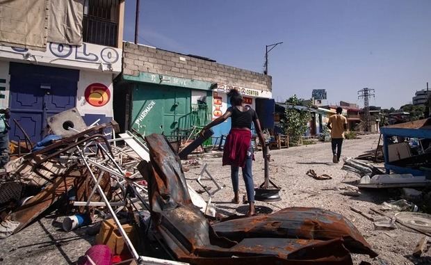 Personas transitan por una calle con barricadas, el 27 de agosto de 2025, tras regresar a su hogar en el barrio Nazon, en Puerto Príncipe (Haití). 