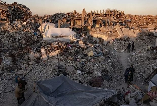 Palestinos caminan junto a edificios destruidos en el campo de refugiados de Yabalia, en el norte de la Franja de Gaza, en una imagen de archivo.