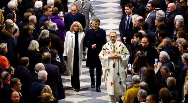 El presidente francés, Emmanuel Macron (D), y su esposa, Brigitte, llegan para asistir a la Misa inaugural, con la consagración del altar mayor, en la Catedral de Notre-Dame de París.