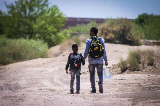 Personas migrantes acercándose a la frontera estadounidense desde Ciudad Juárez México.