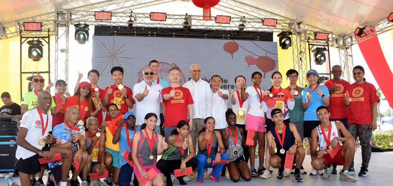 Al centro el embajador Chen Luning, Rafael Salazar, Miguel Feng y José Ramón Holguín, Wendy Reynoso y Elpidio Vargas junto a los corredores ganadores de los 5K.
